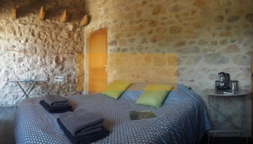 une chambre avec un lit dans un mur de pierre dans l'établissement Odyssée-Auvergne, à Vallon-en-Sully
