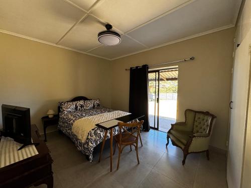 a bedroom with a bed and a table and a chair at Willow Cottage in Evander