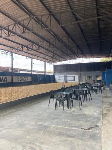 a group of tables and chairs in a baseball field at Pousada Flat Royal - Flat 03 in Itapecerica