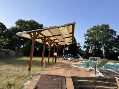une terrasse en bois avec un pavillon à côté d'une piscine dans l'établissement Agriturismo Campo Ruffaldo, à Fattoria la Marsiliana