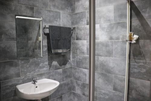 um banheiro com uma pia e um espelho em Glowti Event & Guest House em Centurion