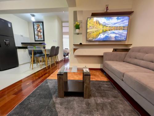 a living room with a couch and a flat screen tv at Terrazas Cusco in Cusco