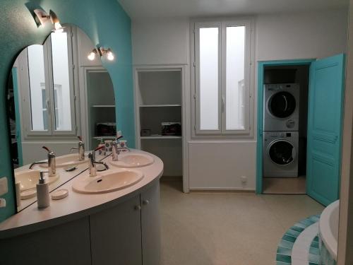 une salle de bain avec deux lavabos et une machine à laver dans l'établissement Un Noël paisible, entre douceur,magie et surprise !, à Castelnau-de-Montratier