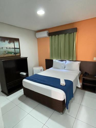 a bedroom with a large bed and a mirror at CR Hotel Bueno in Goiânia