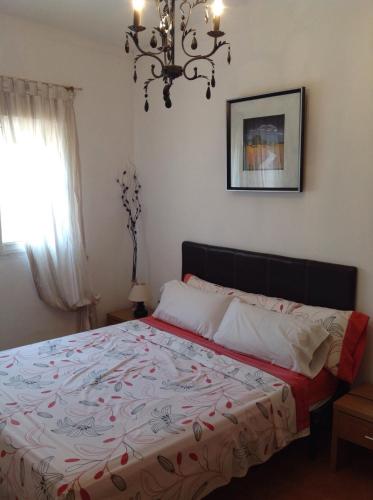 a bedroom with a bed with a red and white blanket at Casita Ramona in Valencia