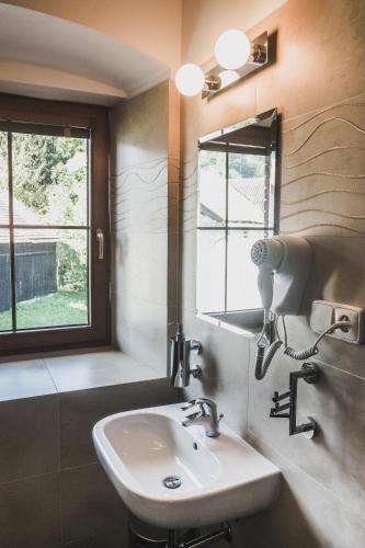 a bathroom with a sink and a mirror and a window at Chata Trojkámen in Nové Losiny