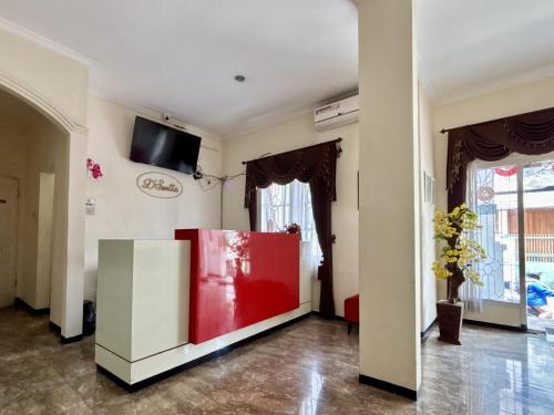 a living room with a red and white wall at YUTAKA INN Malang Suhat Raya in Blimbing