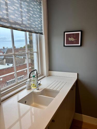 a kitchen counter with a sink and a window at Aspen-free parking-Grade II listed-second floor two bedrooms apartment in Huntingdon