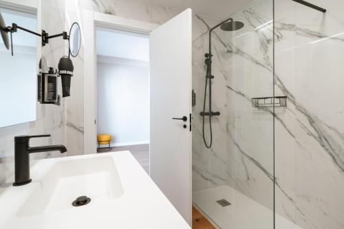 a bathroom with a sink and a shower at Limehome Benidorm Calle Mayor in Benidorm