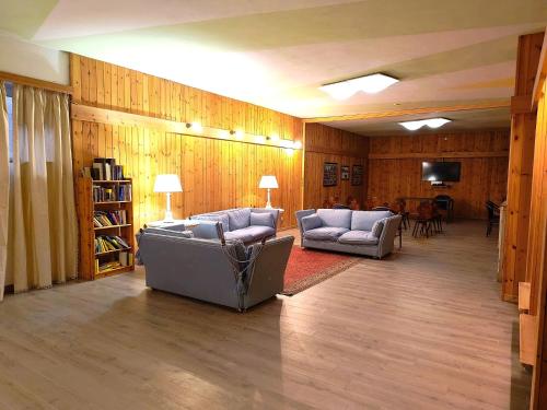 a living room with two couches and a television at Aparthotel Carbonin in Dobbiaco