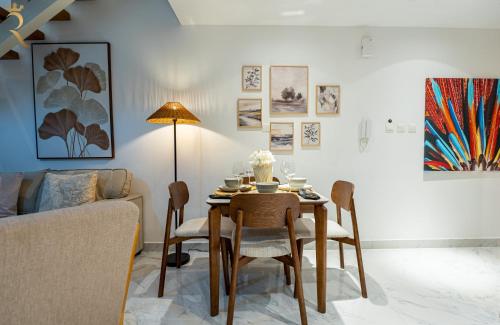 a living room with a table with chairs and a couch at 2BR Poolside Luxe - Chic Serene Escape in Abu Dhabi