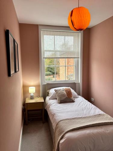 a small bedroom with a bed and a window at Aspen-free parking-Grade II listed-second floor two bedrooms apartment in Huntingdon