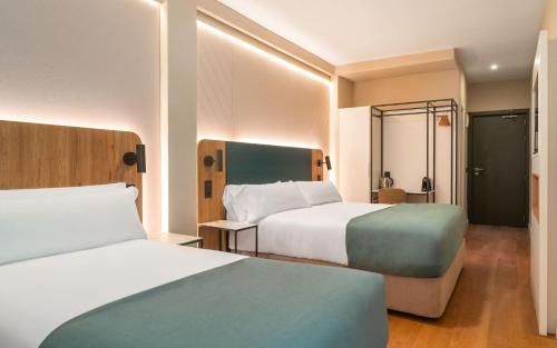 a hotel room with two beds and a bathroom at Limehome Benidorm Calle Mayor in Benidorm