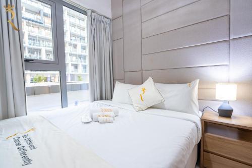 a bedroom with a white bed with a window at 2BR Poolside Luxe - Chic Serene Escape in Abu Dhabi