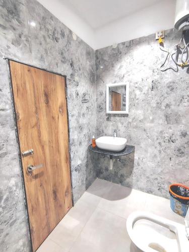 a bathroom with a wooden door and a sink at Happy Villa Regency in Guwahati