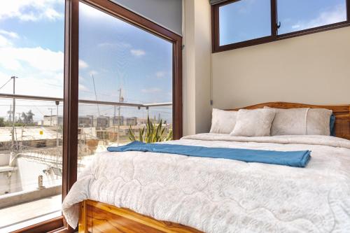 ein Schlafzimmer mit einem Bett und einem großen Fenster in der Unterkunft Yesimar Hotel in Salinas