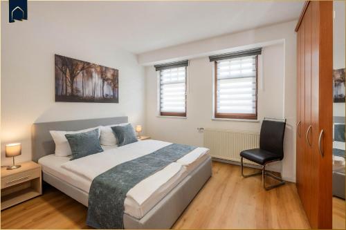 a bedroom with a bed and a chair in it at 257 Haus Otto in Ahlbeck