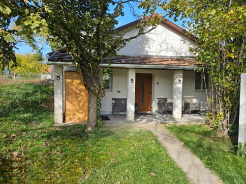 a small white house with a tree in the yard at Marina Cottage in Enying