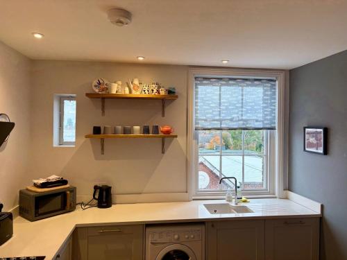 a kitchen with a sink and a window at Aspen-free parking-Grade II listed-second floor two bedrooms apartment in Huntingdon