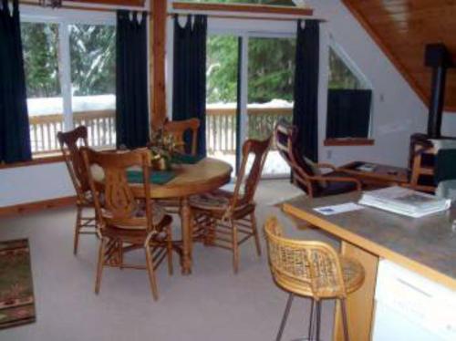 a living room with a wooden table and chairs at Crystal Carriage House in Greenwater