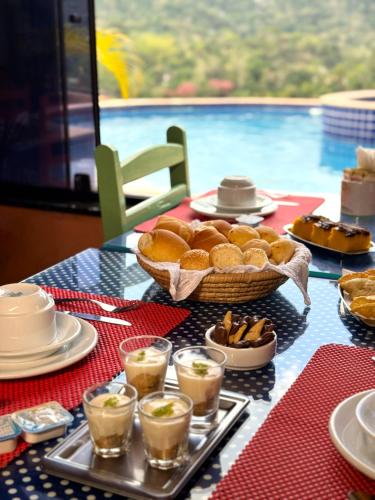 a table with a plate of food and a basket of bread at Pousada Santa Fe de Penedo in Penedo