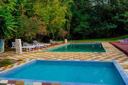 a swimming pool in a yard with tables and chairs at Pine 2 bedroom apartment with a pool in Nanyuki