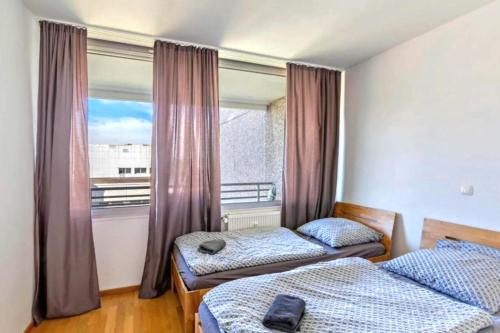 - une chambre avec 2 lits et une fenêtre avec un balcon dans l'établissement Stunning 1-Bed Apartment in Neuss, à Neuss