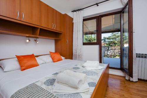 - une chambre dotée d'un lit avec des serviettes orange et blanches dans l'établissement Apartments Valdibora, à Rovinj