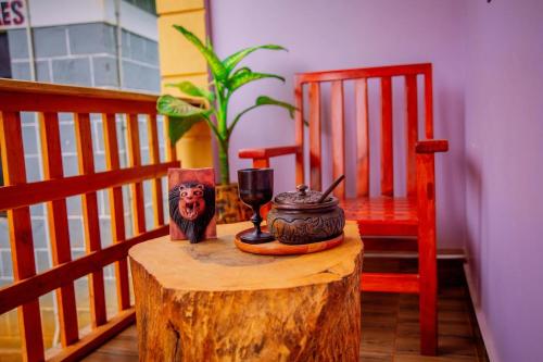 une table avec un tronc d'arbre, une chaise et une bougie dans l'établissement Materuni Home Stay, à Uru East