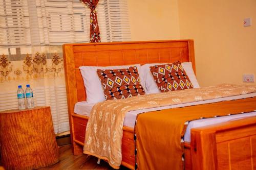 a bedroom with a wooden bed with pillows at Materuni Home Stay in Uru East