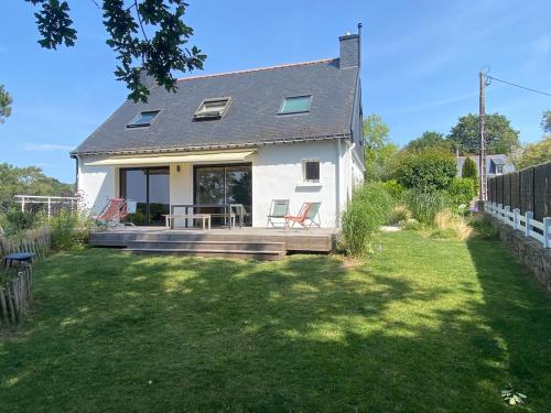 une maison avec un porche avec deux chaises dessus dans l'établissement Maison sur le golfe du Morbihan vue mer, à Plougoumelen