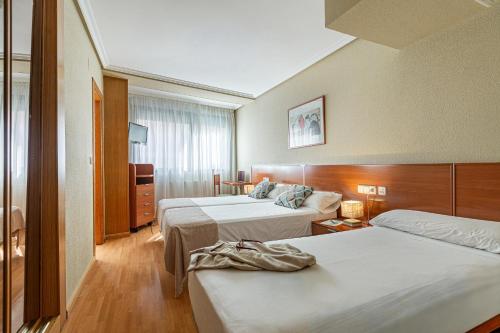 a hotel room with two beds and a room with at IRAIPE Achuri Auto Check-in in Miranda de Ebro