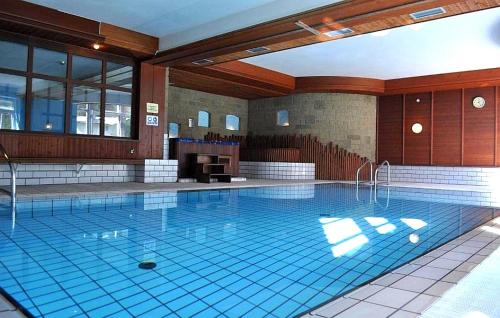 a large swimming pool in a large building at Aparthotel Carbonin in Dobbiaco