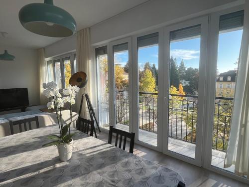 a dining room with large windows and a table with a view at Genieße Bad Gleichenberg direkt am Hauptplatz in Bad Gleichenberg