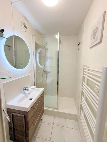 ein Badezimmer mit Waschbecken und Dusche in der Unterkunft Cabourg Mathilde in Cabourg