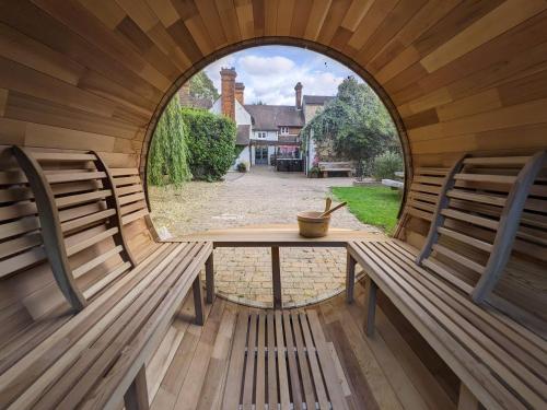 an arched window in a wooden room with benches at A historic Pub with a modern twist - The Greyhound in Bury Saint Edmunds