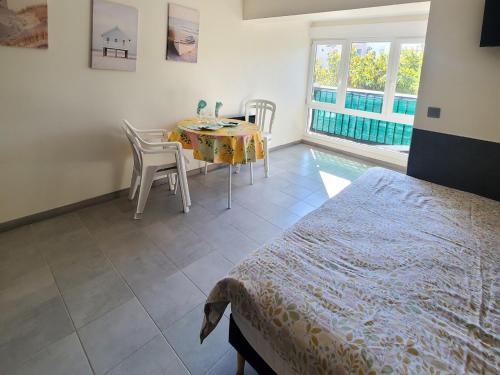 ein Schlafzimmer mit einem Tisch, einem Tisch und Stühlen in der Unterkunft A 100m de la plage A3, Rez-de-chaussee in Cap d'Agde