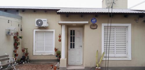 ein Haus mit zwei Fenstern und einer weißen Tür in der Unterkunft Casa en Pueblo Esther in Pueblo Esther