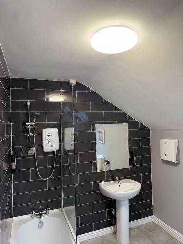 a bathroom with a sink and a shower and a toilet at Stylish 3 BR home & Game room & Family Lounge in Dudley