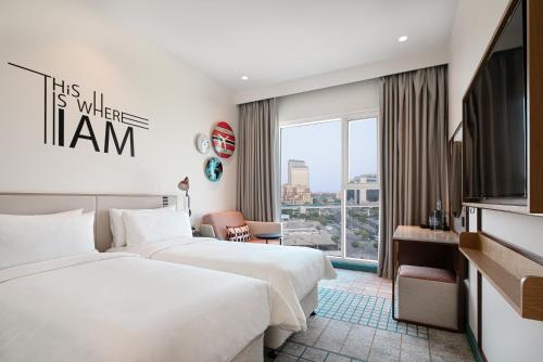 une chambre d'hôtel avec deux lits et une fenêtre dans l'établissement Rove Healthcare City - Bur Dubai, à Dubaï