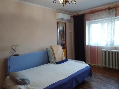 a bedroom with a blue bed and a window at 1BR Budget Apartment near Beach in Constanţa