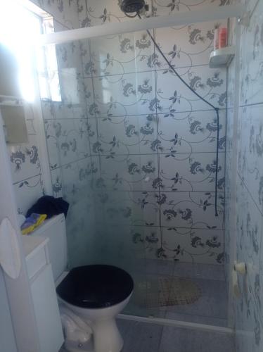 モンガグァーにあるcantinho da Renata monguaguaの壁紙が貼られたトイレとシャワー付きのバスルーム