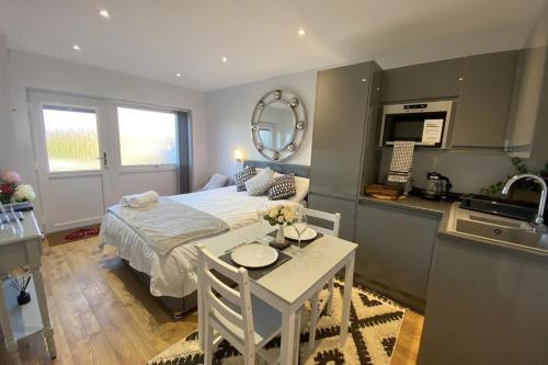 a bedroom with a bed and a table and a kitchen at Beautiful 1-Bed studio in Penrith in Penrith