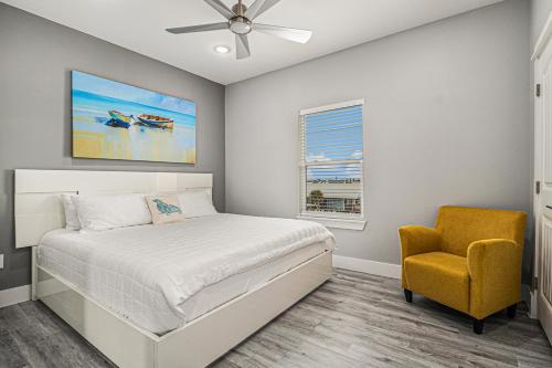 a bedroom with a bed and a yellow chair at Luxury Beachfront Family Fun Sleeps 22 in Surfside Beach