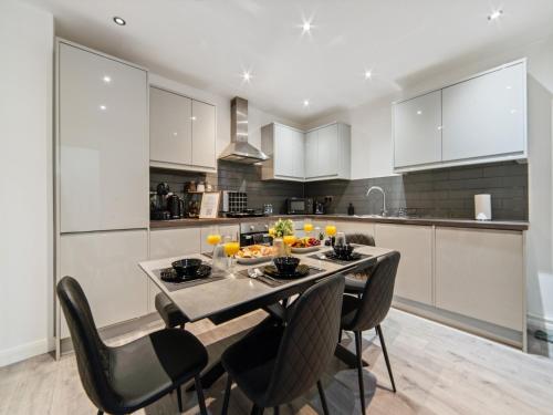 a kitchen with a dining table and chairs in a room at The Sapphire Suite - 2BR 2Bath City Centre in Leicester