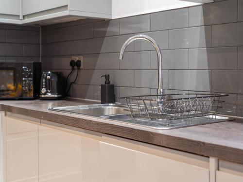 a kitchen counter with a sink and a faucet at The Sapphire Suite - 2BR 2Bath City Centre in Leicester