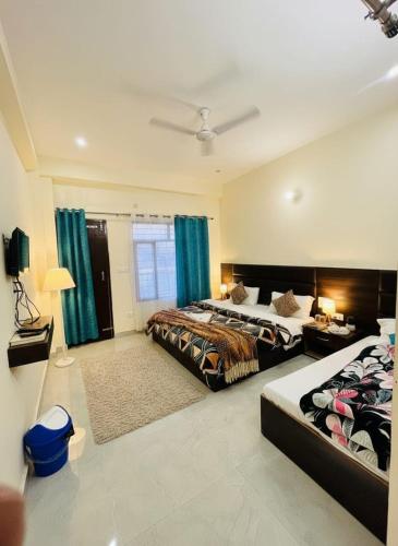 two beds in a bedroom with blue curtains at Aman Nest in Jāmb