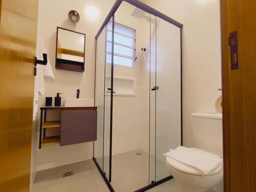 une salle de bain avec toilettes et douche en verre dans l'établissement Compact Home Campinas, à Campinas