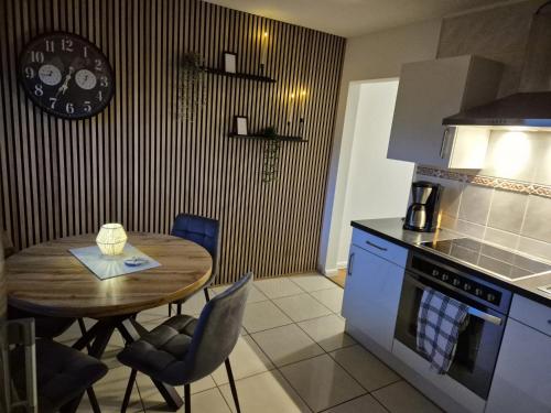 a kitchen with a wooden table and a dining room at Ferienwohnung Fehnzeit in Rhauderfehn