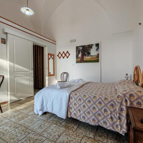 a bedroom with a bed and a table and a door at Terra di Leuca in Salve